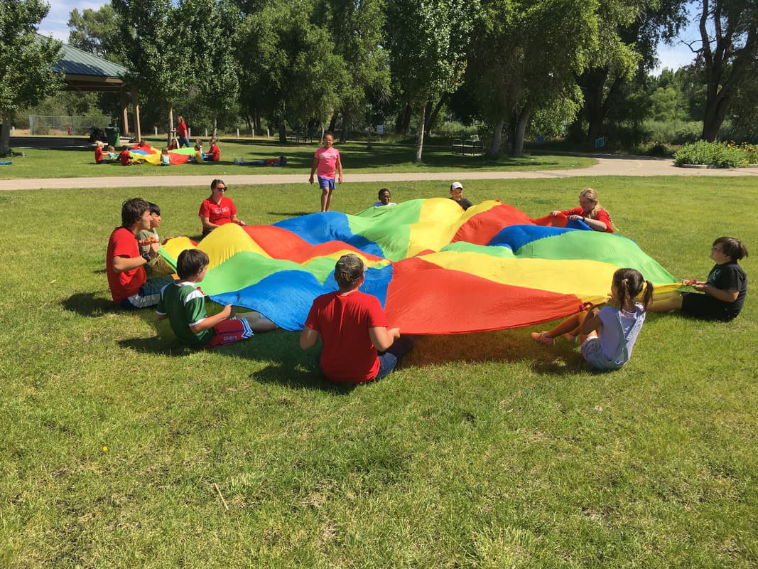 Children and Leaders Playing Parachute Games at a 5-Day Club